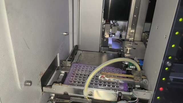 An automated blood grouping analyzer performs precision sample testing using a rotating carousel and robotic probe.