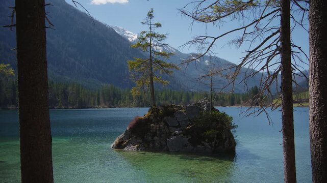 Turquoise mountain lake Hintersee, Berchtesgaden. Scenic stone islands with trees, green spring forest.