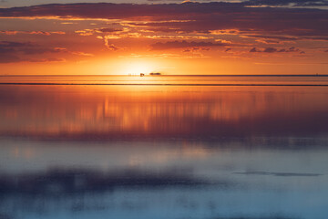 Obraz premium Serene sunset reflection over Salar de Uyuni salt flat in Bolivia