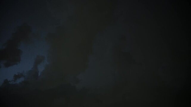 Dark storm clouds with endless lightning in night sky. Dramatic thunderstorm, heavy weather, atmospheric background.