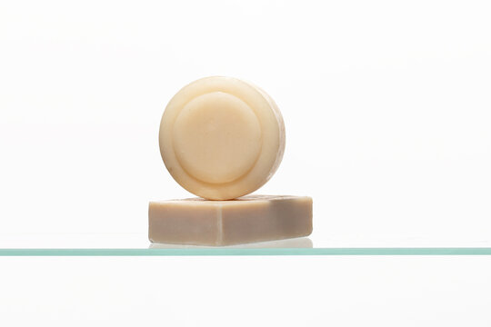 Two artesian soap cleansers stacked on a bath shelf , natural ingredients and a gentle skincare approach. Abstract visual for clean natural product and skincare