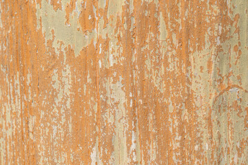 Fototapeta premium Peeling orange wall texture with vertical streaks and weathered paint, ideal for grunge background, abstract design, and urban decay concept.