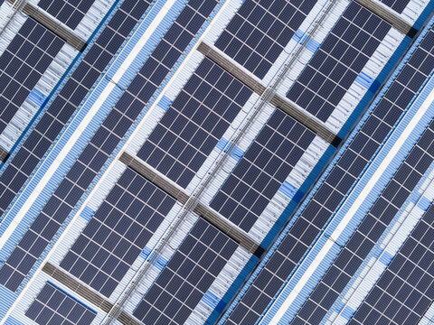 Aerial view of solar panels on a modern industrial rooftop with blue and white corrugated metal sheets in Taiwan.