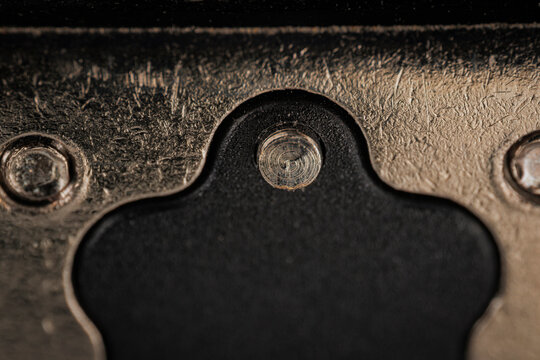 Macro closeup of camera hotshoe mount with central contact and metal rails showing textured surface and photography equipment detail