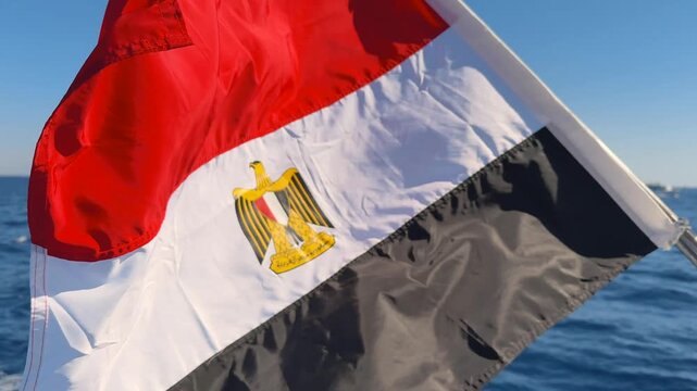 Close up of Egypt national flag on boat upper deck waving in the strong wind