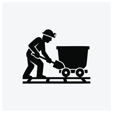 Silhouette of a worker using a scooper to load a cart on tracks.