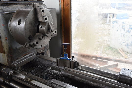 Industrial metal lathe with three-jaw self-centering chuck and quick-change tool post assembly