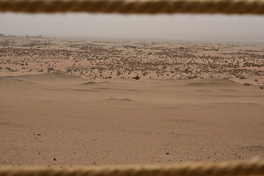 A narrow path winds through the barren desert, its dusty trail disappearing into the endless horizon, inviting wanderers to step into the unknown.