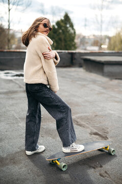 Confident young posing with skateboard on roof top
