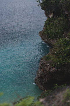 Dramatic limestone cliff over turquoise ocean water, Bali