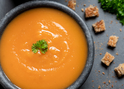 Warm bowl of winter soup with croutons to the side