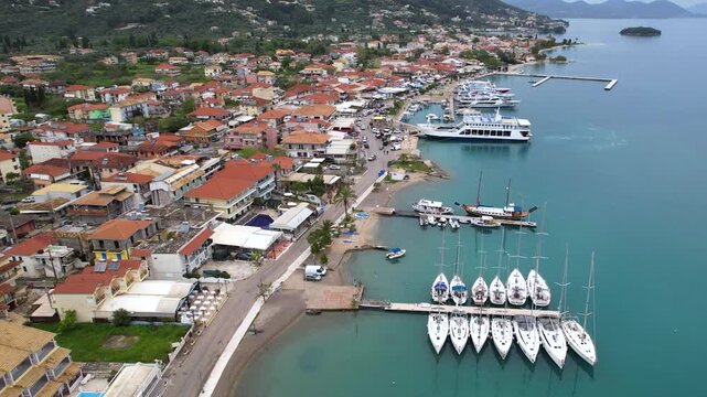 Drone Dolly Shot in Nydri Lafkada Island, Vessels Docked and Ferry Arrival, Panoramic View of City Marina, Summer Destination Greece