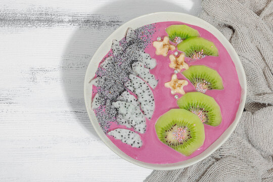Pitaya smoothie bowl with fruit, kiwi, banana, and poppy seeds. Trendy food, healthy breakfast idea