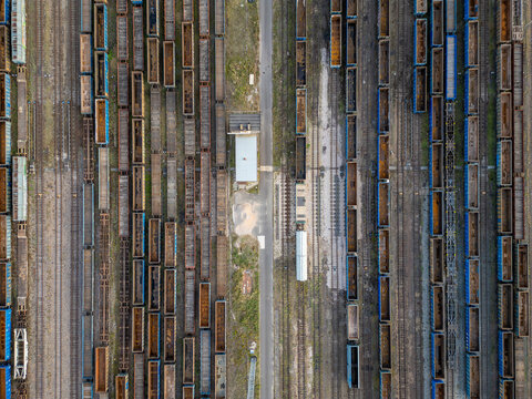 Aerial view of rows of freight train wagons and cargo containers on parallel railway tracks at a logistics terminal in Warsaw, Masovian Voivodeship, Poland.