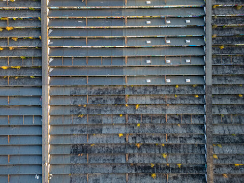 Aerial view of concrete old warehouse rooftop with small plants growing between the panels in Warsaw, Masovian Voivodeship, Poland.