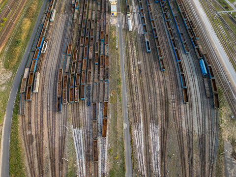 Aerial view of a large railway freight yard with numerous cargo wagons parked on parallel tracks in Warsaw, Masovian Voivodeship, Poland.