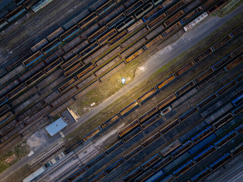 Aerial view of rows of empty freight train wagons parked on multiple tracks at a large railway cargo terminal in Warsaw, Masovian Voivodeship, Poland.