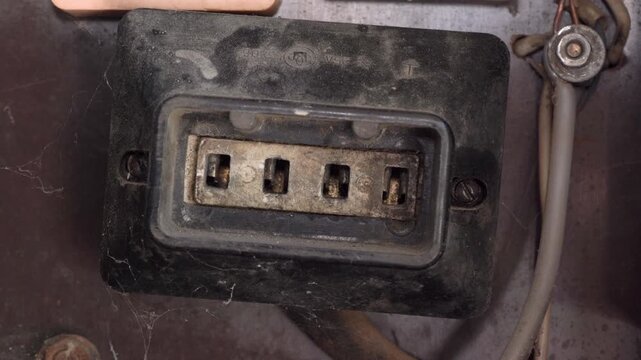 Old electrical socket or connector in dusty industrial condition, A close-up of a vintage three-phase socket of a rectangular shape, covered with a layer of dust and cobwebs.
