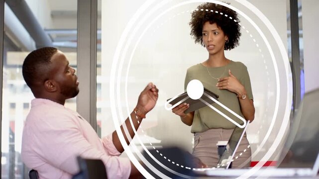 Woman holding tablet initiating animated clock while presenting to man in business emphasizing time