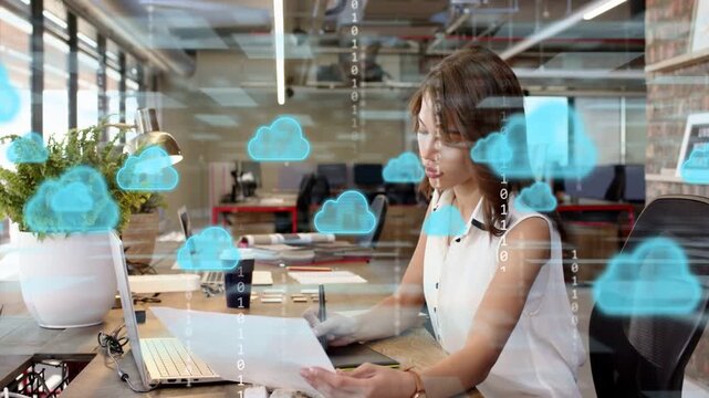 Designer using stylus checking sheets for tech, activating cloud binary overlay denser, smiling