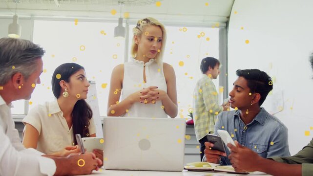 Business lead glancing notes sharing plan, gesturing while team noting phones yellow dots over lead