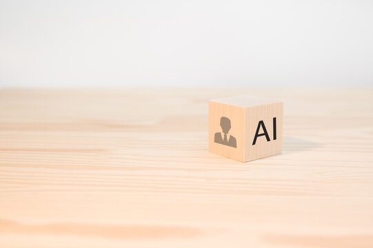 AI replacing traditional HR and the future of work. Wooden cube with AI text and human icon. Artificial intelligence replacing traditional HR roles, automation and the future of workforce management.