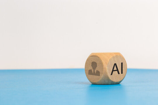 AI replacing traditional HR and the future of work. Wooden cube with AI text and human icon. Artificial intelligence replacing traditional HR roles, automation and the future of workforce management.