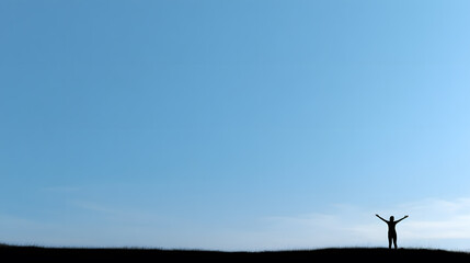 Fototapeta premium Silhouette of person celebrating on hilltop against clear blue sky
