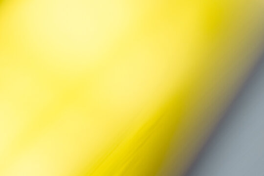 A soft yellow light gradient merges into a desaturated grey via motion blur. 