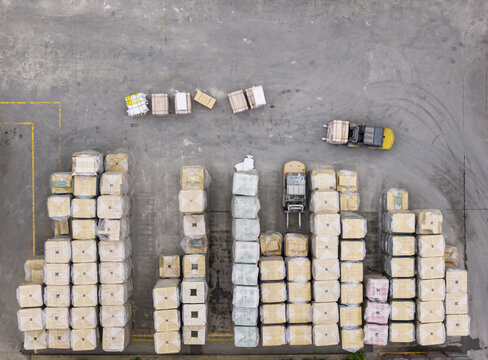 Aerial view of organized stacks of palletized cargo and forklifts operating in an industrial logistics yard in Taiwan.