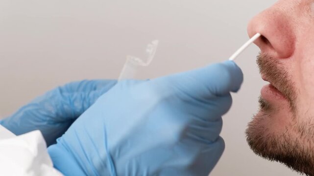 Close-up of a medical professional performing a nasal swab test, representing virus detection, covid testing, and healthcare safety.