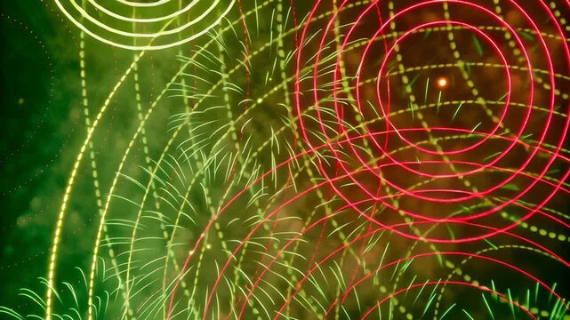 Colorful fireworks bursting with glowing trails concept. Colorful vibrant fireworks display with red and green spiral light trails in night sky