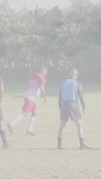 Vertical video: Red striker placing ball by goal, defenders backing to net, ref gesturing sports