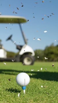 Vertical video: Gloved hand entering placing ball on tee, bits drifting, driver coming aiming shot