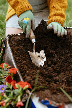 Garden trowel scooping soil from bag for planting in pot