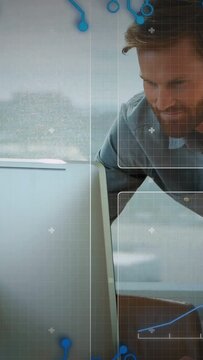 Vertical video: Dev leaning, typing to analyze chart as animated code icons appearing on monitor
