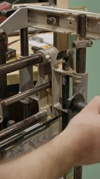 Close-up vertical shot of a woodworking jig system guiding a cutting tool to
create a precise mortise slot in a wooden workpiece. The setup includes metal guide rails, clamps, and adjustment knobs.