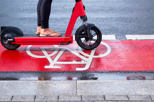Scooter on pavement crosses marked bicycle lane in Frankfurt Germany with urban mobility theme for daily commute transportation lifestyle