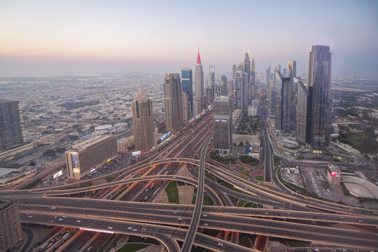 Aerial view of the modern skyscrapers and complex highway interchanges along Sheikh Zayed Road at dusk in Dubai, Dubai, United Arab Emirates.