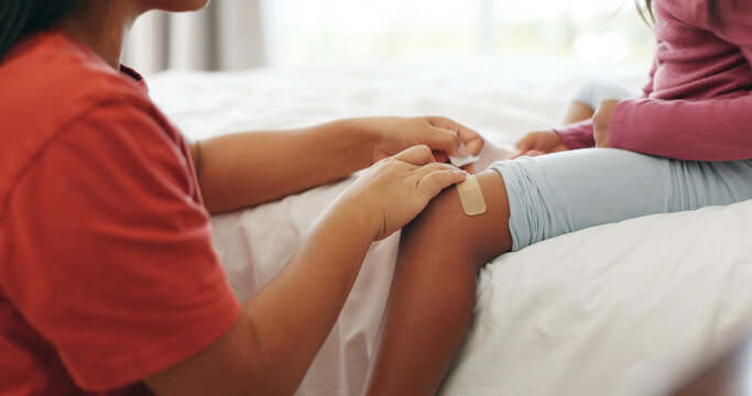 Mother, child and bandage in home with knee injury, first aid assistance and wound from accident. Woman, daughter and help in bedroom with plaster, bruise and healing support for hurt leg in house.