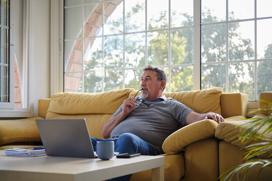 Mature man thinking while freelancing at home