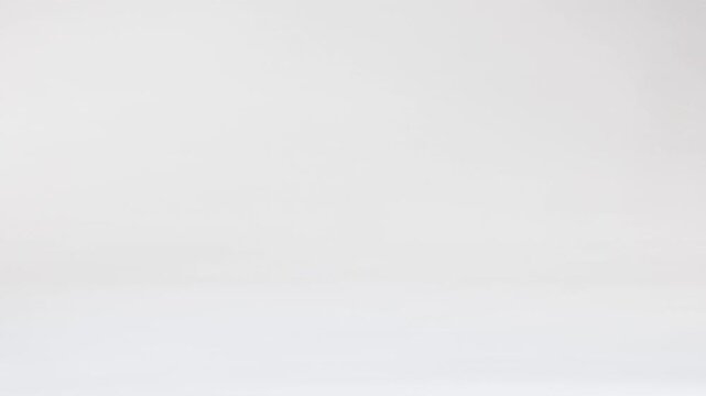 Miniature Soccer Ball Bouncing and Rolling on White Background