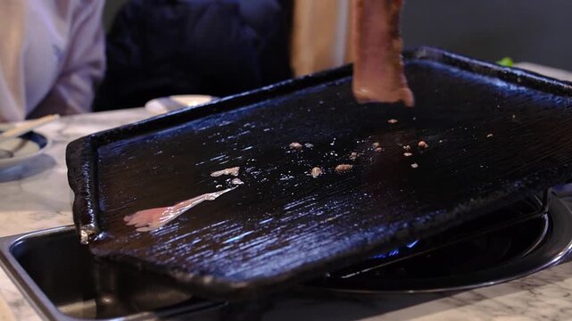 Sizzling pork belly on a hot grill with melting fat, Korean BBQ style