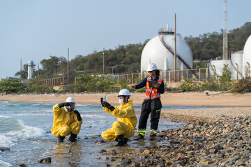 Fototapeta premium Environmental engineers in hazmat suits collecting and inspecting water samples near industrial gas storage tanks for pollution and safety monitoring.