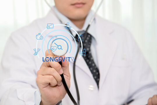 Doctor wearing a white lab coat and holding a stethoscop touching a longevity icon that represents preventive healthcare, anti-aging, and the concept of extending a healthy lifespan .