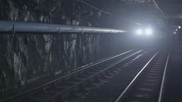 Underground railway tracks in a dark mine tunnel
