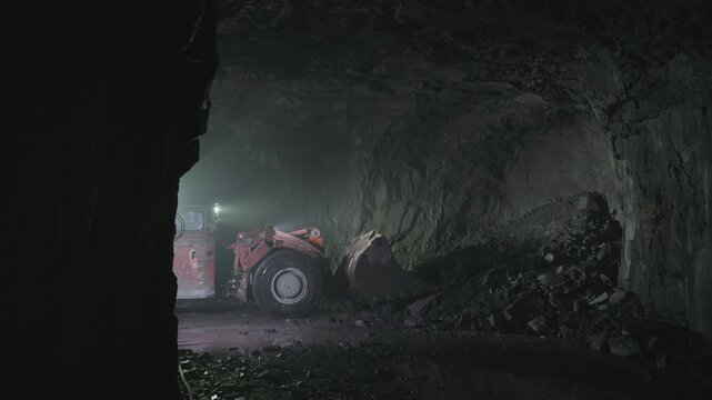 A loader loads iron ore in a mine