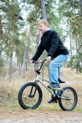 Naklejka premium Teenager Riding a BMX Bicycle on a Forest Trail, Extreme Sports and Active Lifestyle Outdoors