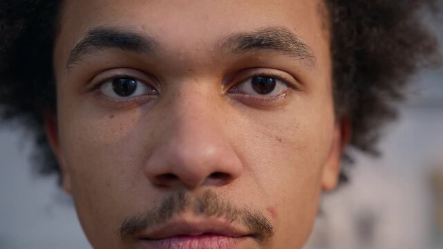 Extreme close up portrait African American man looking down eyes closed male guy ethnic young adult calm home indoors healthy skin facial expression student client thoughtful serene apartment kitchen