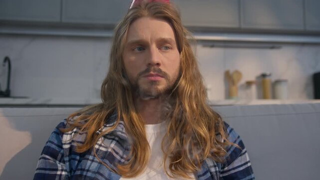 Frustrated depressed Caucasian birthday man guy blowing candles cake at home room sad male alone without friends family quarantine lockdown isolation upset celebrating indoor despair stress event fail